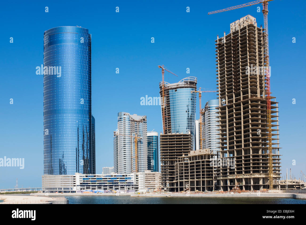 Moderno y de gran altura edificios residenciales y de oficinas en construcción en la ciudad de luces encendidas al reem Island, en Abu Dhabi, Emiratos Árabes Unidos Foto de stock