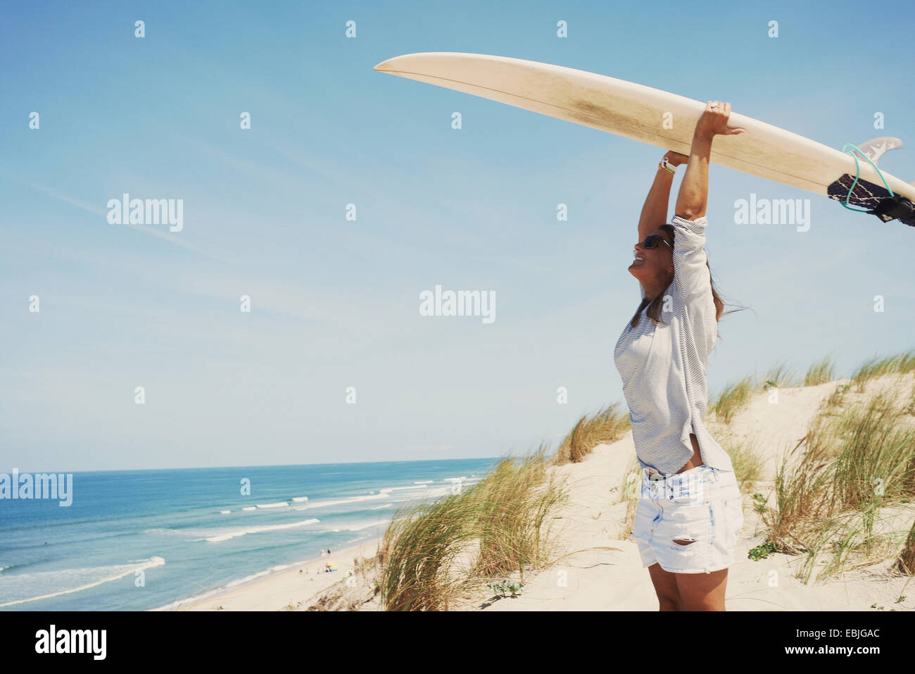 Mujer con tablas de surf en la playa, Lacanau, Francia Foto de stock