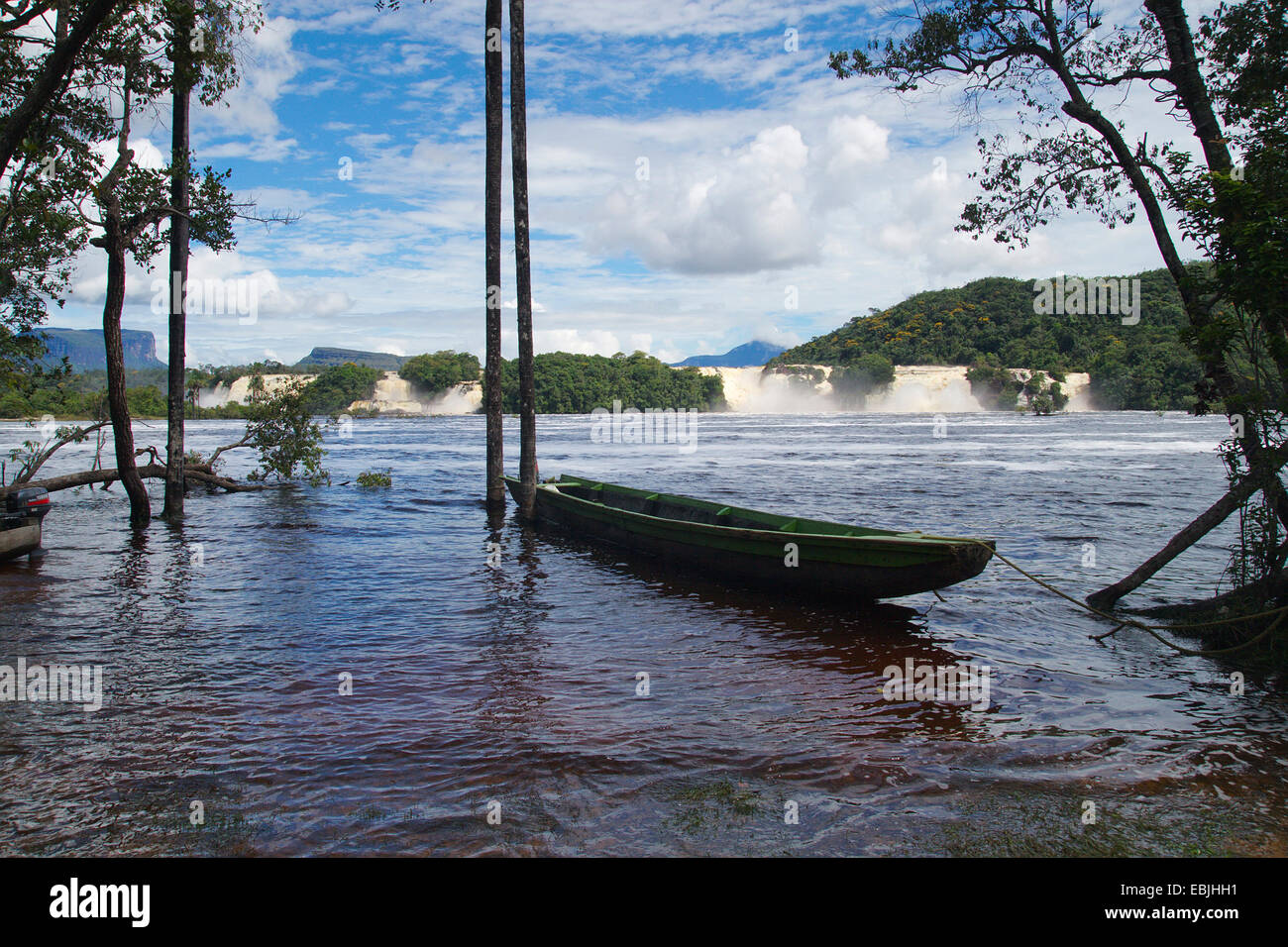 Paisaje de Canaima, con un bote en una laguna alimentada por cascadas, Venezuela, el Parque Nacional de Canaima Foto de stock