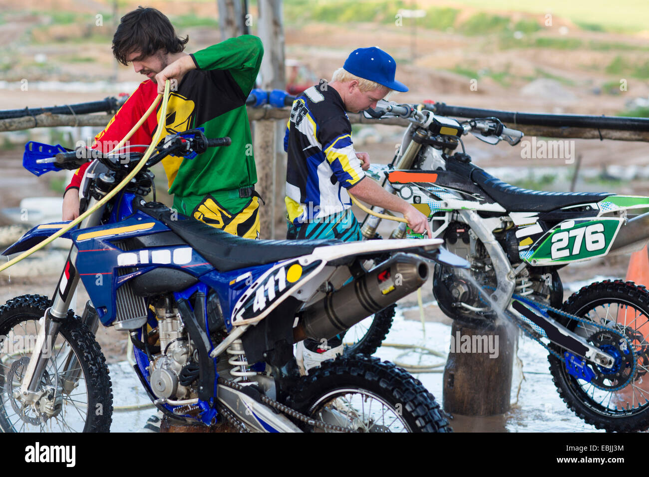 Dos machos competidores de motocross motos de limpieza con mangueras de agua Foto de stock