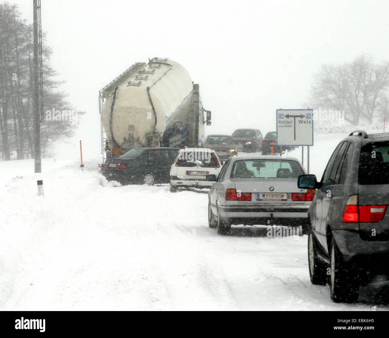 El caos del tráfico en una carretera cubierta de nieve con nieve fresca Foto de stock