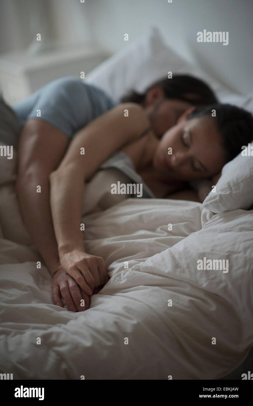 Pareja durmiendo juntos en la cama en la noche Fotografía de stock - Alamy