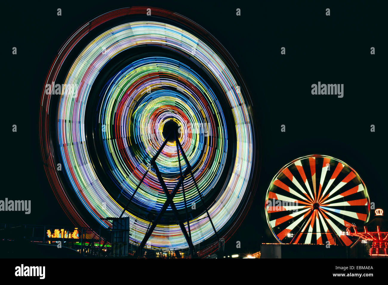 La larga exposición de ruedas de Ferris en la noche en un carnaval Foto de stock