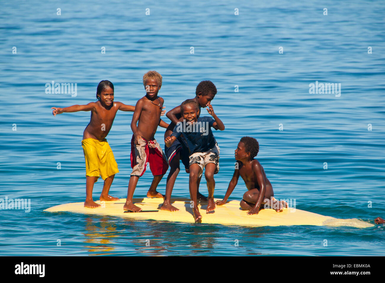 Niños jugando con una tabla de surf, Savo, provincia central de la isla,  Islas Salomón Fotografía de stock - Alamy
