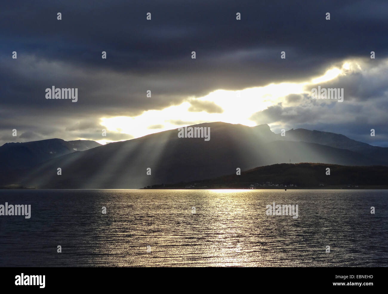 Rayos crepusculares rompiendo nubes sobre Lille Blamannen, Noruega Troms, Tromsoe Foto de stock