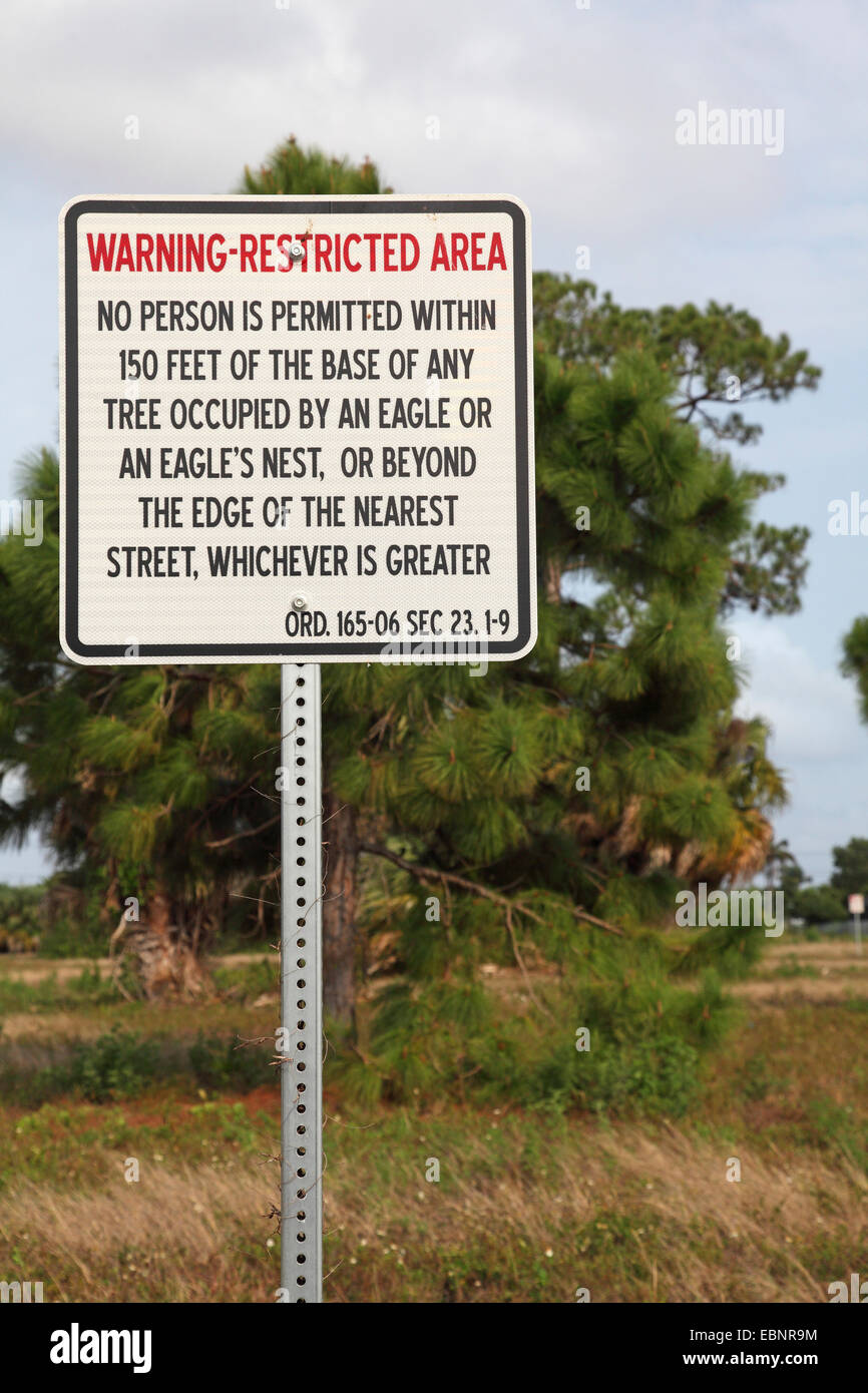 El águila calva americana (Haliaeetus leucocephalus), Etiqueta de advertencia prohibido entrar en el área alrededor del nido del águila calva americana, EEUU, Florida, Merritt Island Foto de stock