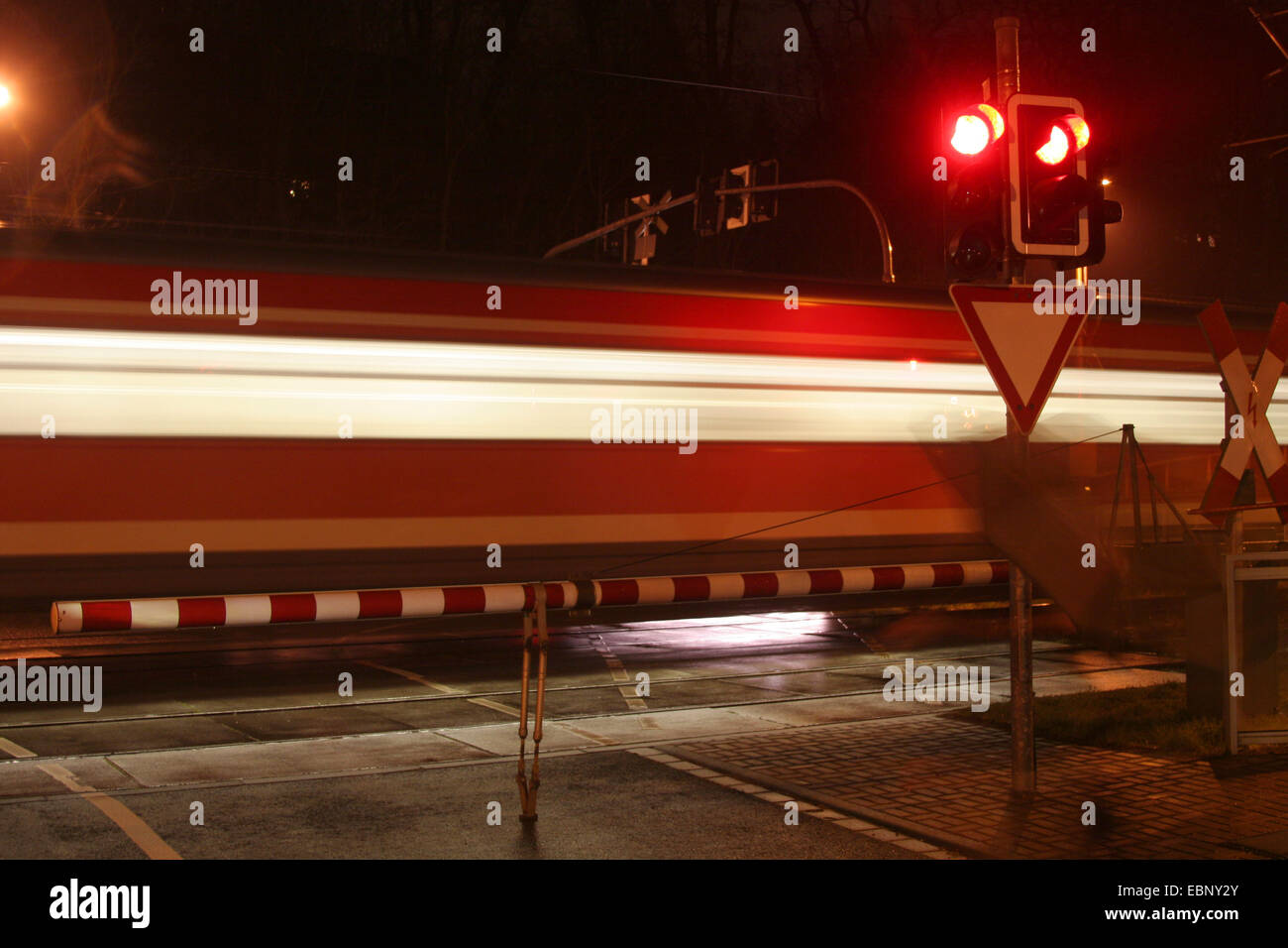 Tren pasa un cruce ferroviario en la noche, en Alemania, en Renania del Norte-Westfalia Foto de stock