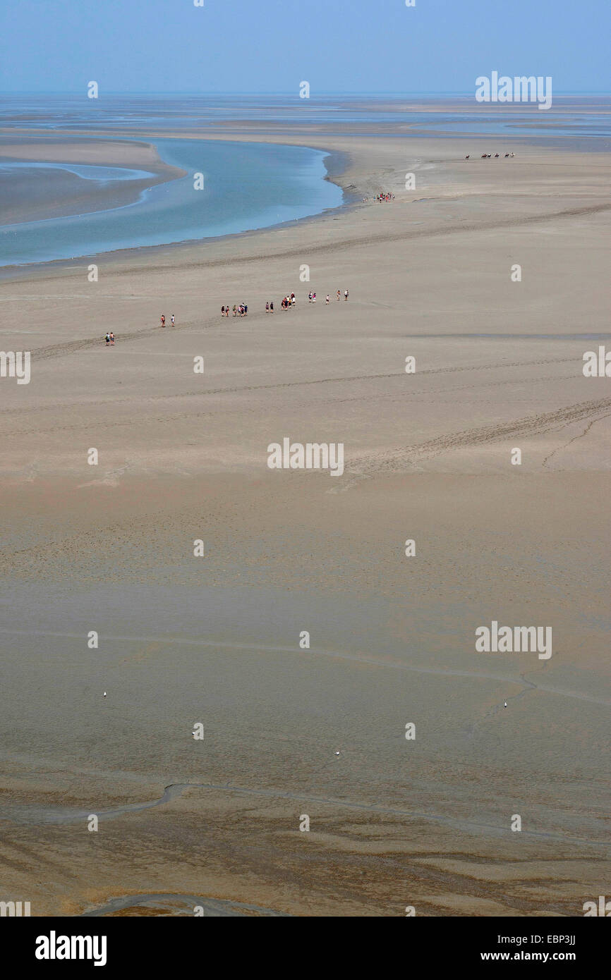 Tideland de arena durante la marea baja, con planos de marea excursionistas, Francia, Bretaña Foto de stock