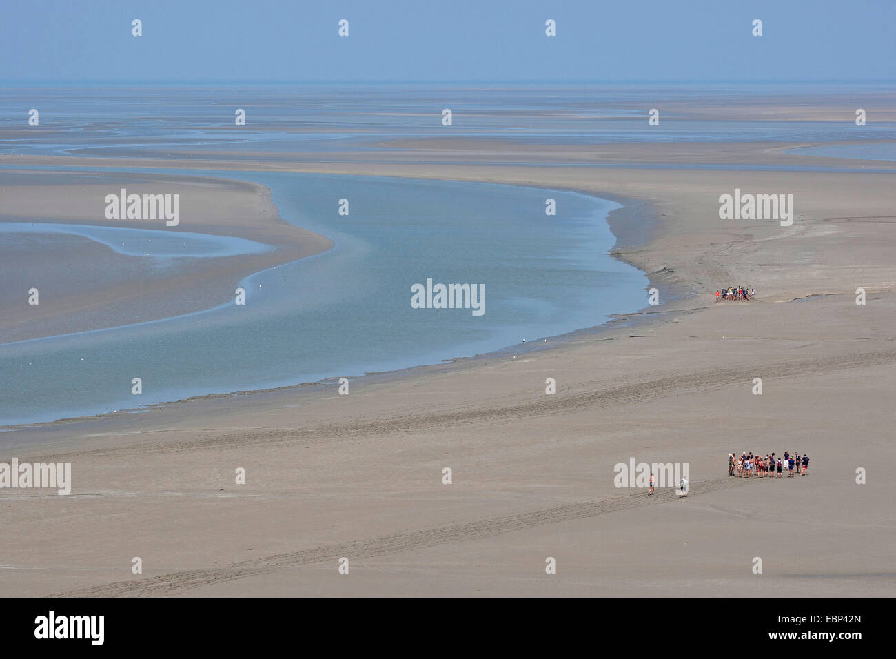 Tideland de arena durante la marea baja, con planos de marea excursionistas, Francia, Bretaña Foto de stock