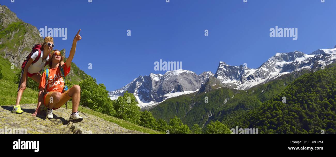 Dos excursionistas mostrando algo en el paisaje de montaña, Grande Casse en segundo plano, Francia, Savoie, Parque Nacional de Vanoise, Valle de Champagny Foto de stock