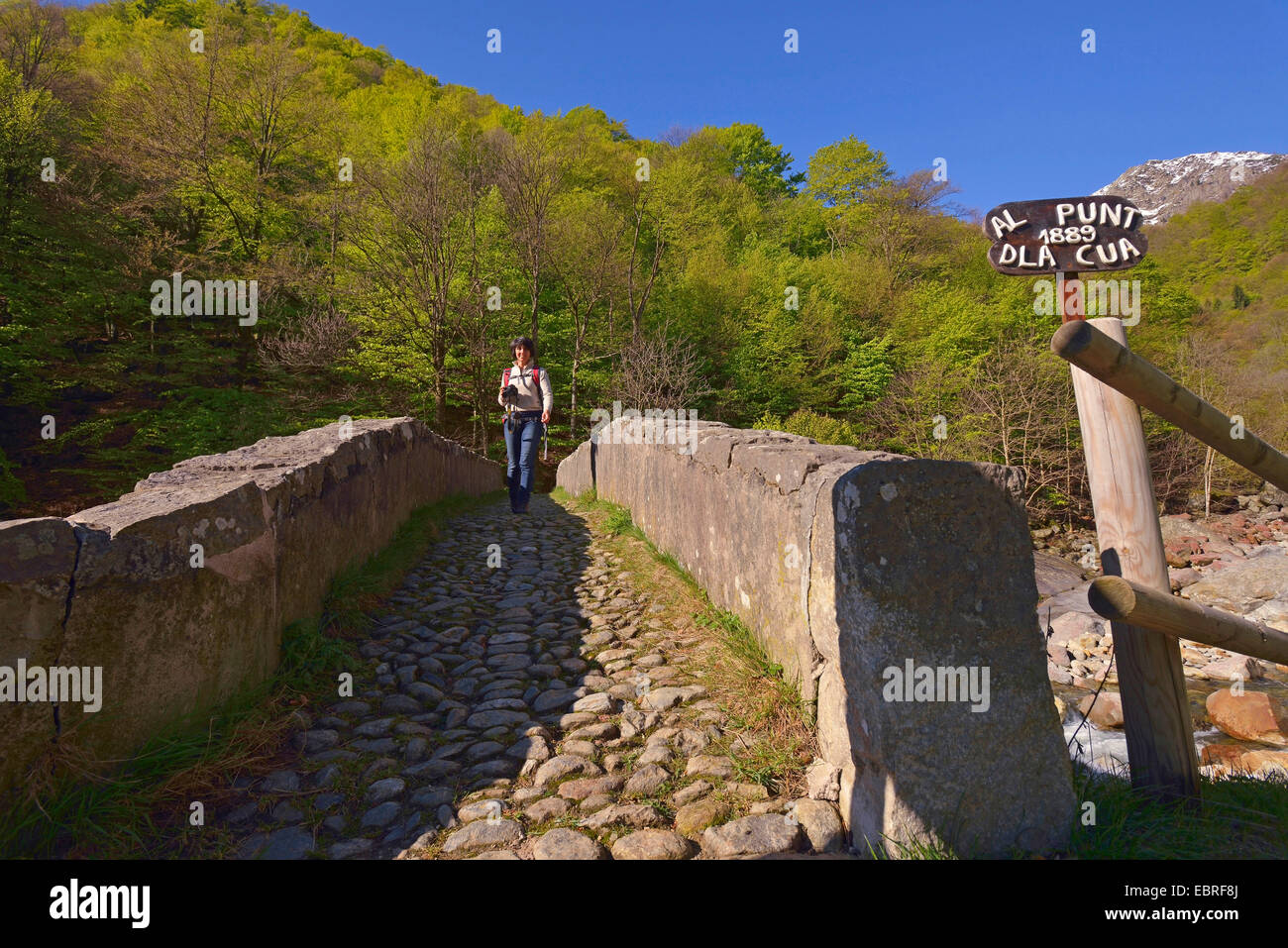 Wanderer femenino sobre el puente de piedra, Italia, Piedicavallo Foto de stock