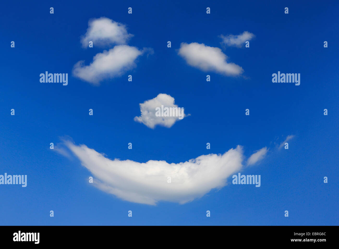Cara sonriente de nubes en el cielo azul Foto de stock