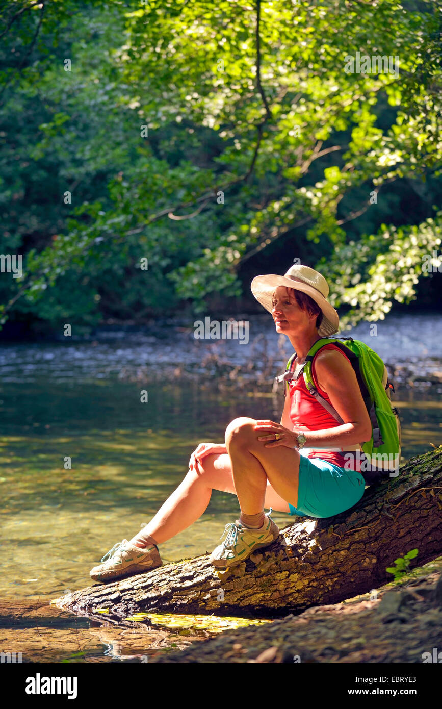 Excursionista femenina sentada sobre el tronco de un árbol y hacer un respiradero, Francia, Alpes Maritimes, gargantas de la Siagne, Monsanto Foto de stock