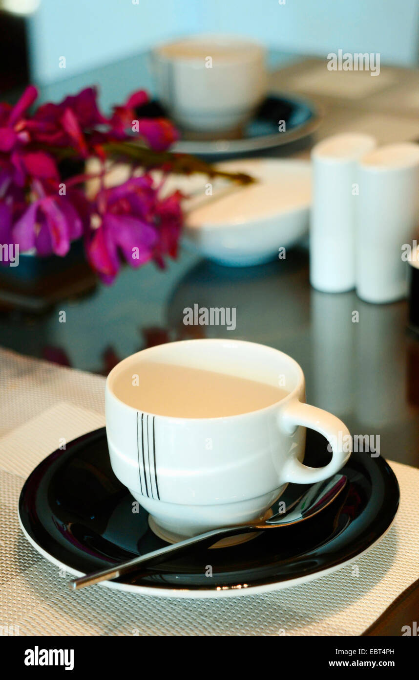 Lugar: un lugar con una taza de café, cristal y cubertería se configuran mediante un toque contemporáneo en un art decó. Foto de stock