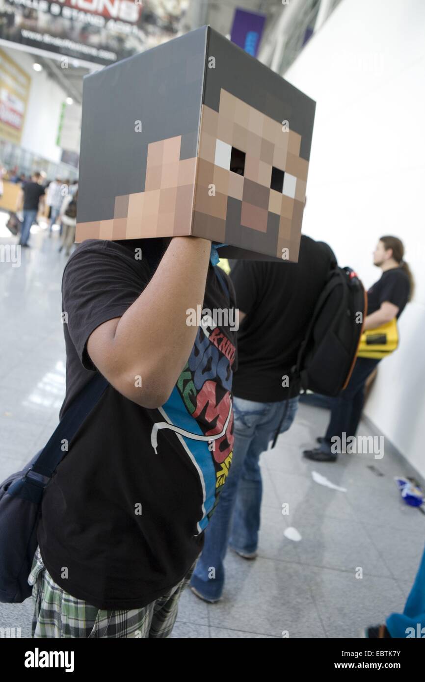 Joven visitante de la Gamescom (la feria más grande del mundo de juegos de vídeo) con una máscara con un píxel se enfrentan, en Alemania, en Renania del Norte-Westfalia, Colonia Foto de stock