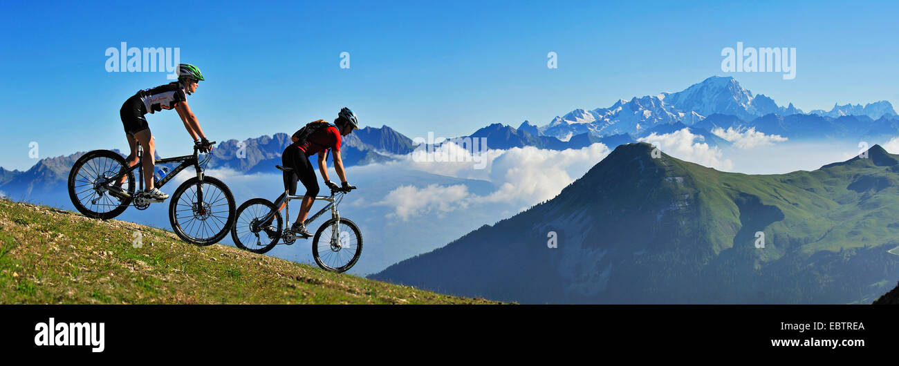 Dos mujeres mountainbikers montar abajo de la ladera de la montaña, Francia, Savoie, Parque Nacional de Vanoise, La Plagne Foto de stock