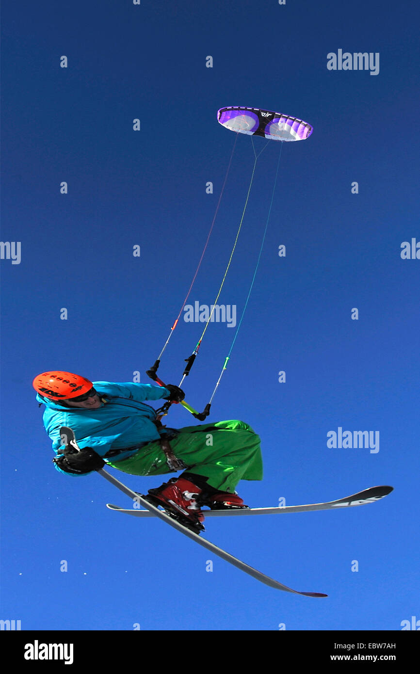 El hombre flotando en frente de clear blue sky parapente con esquíes, Francia Foto de stock