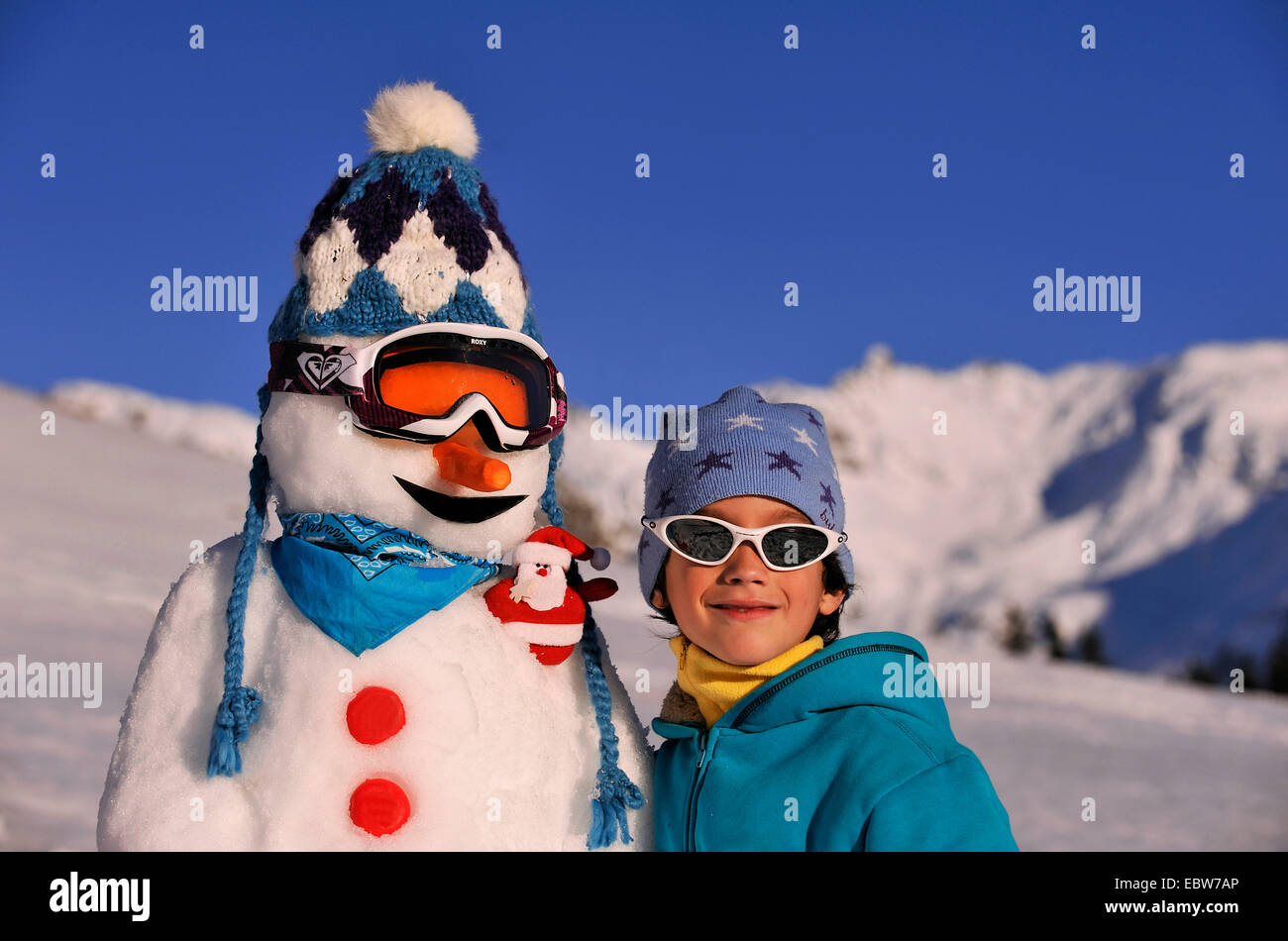 hermosa niña feliz en traje de esquí y sombrero de lana con gafas de  protección en la nieve blanca en las montañas durante el invierno  vacaciones de navidad al aire libre Fotografía de stock - Alamy