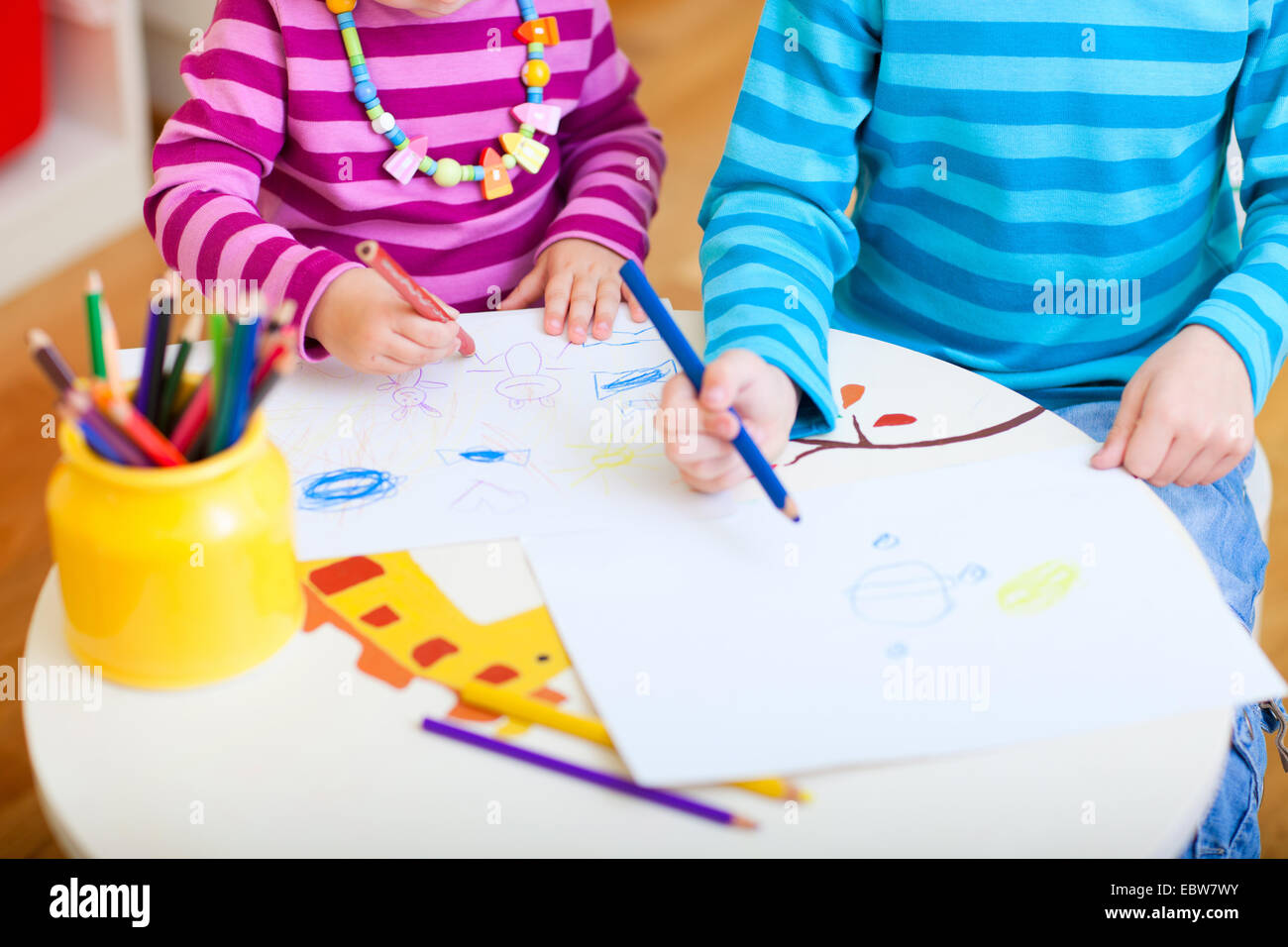 Dos niños pequeños de dibujo con lápices de colores Foto de stock