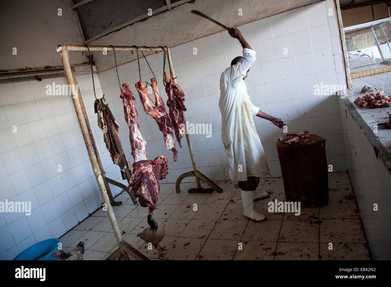 Carnicero cortando la carne en un tronco de madera, en Rwanda, en Nyamirambo, Kigali Foto de stock