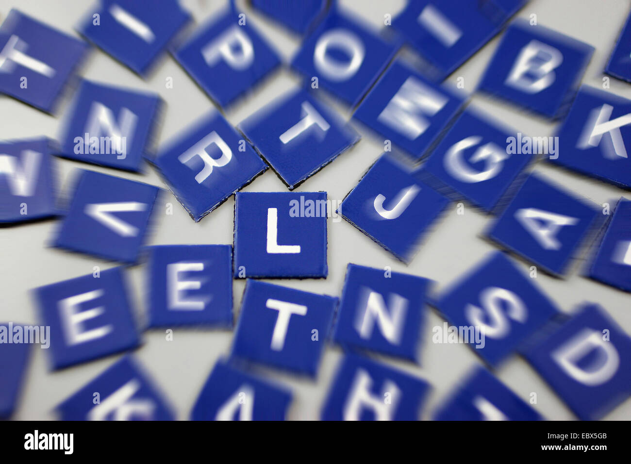 Fichas de Scrabble en azul con foco en L Foto de stock