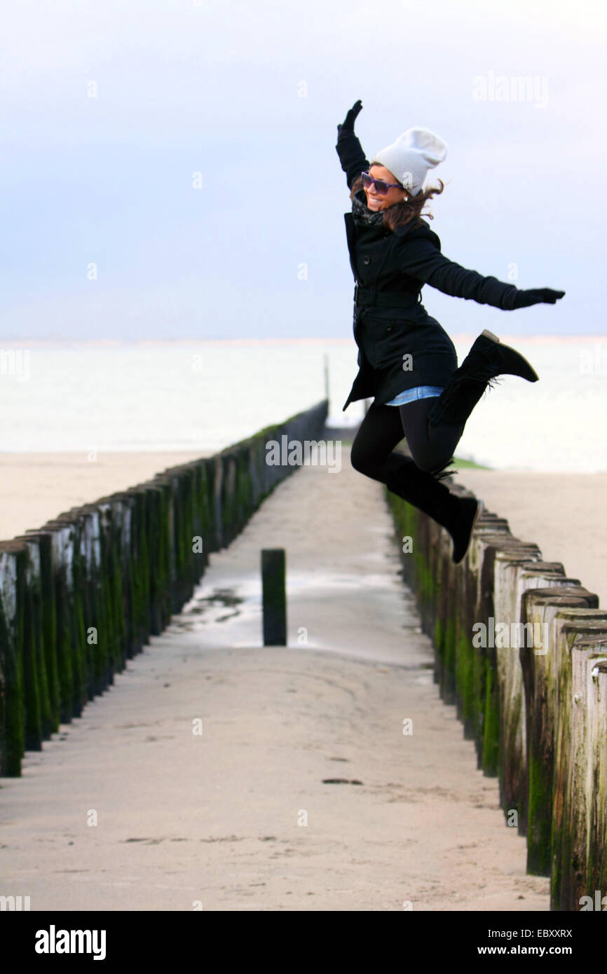 Mujer joven cortando una cabriola en el Mar del Norte, Holanda, Zelanda, Breskens Foto de stock
