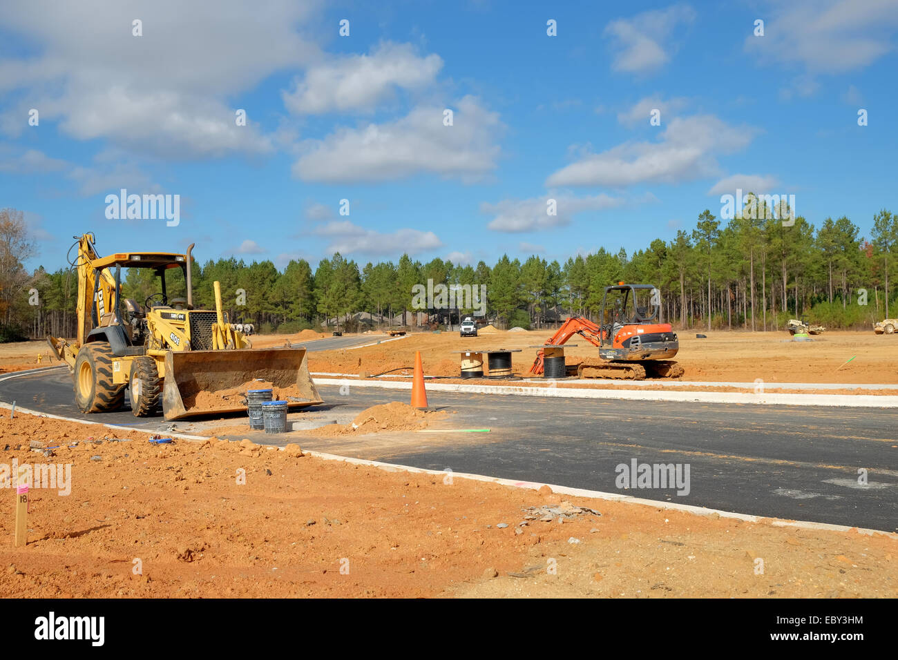 Una retroexcavadora john deere / cargador frontal en primer plano con una pequeña retroexcavadora kubota en el fondo en un sitio de construcción, Pike road, Alabama, Estados Unidos. Foto de stock