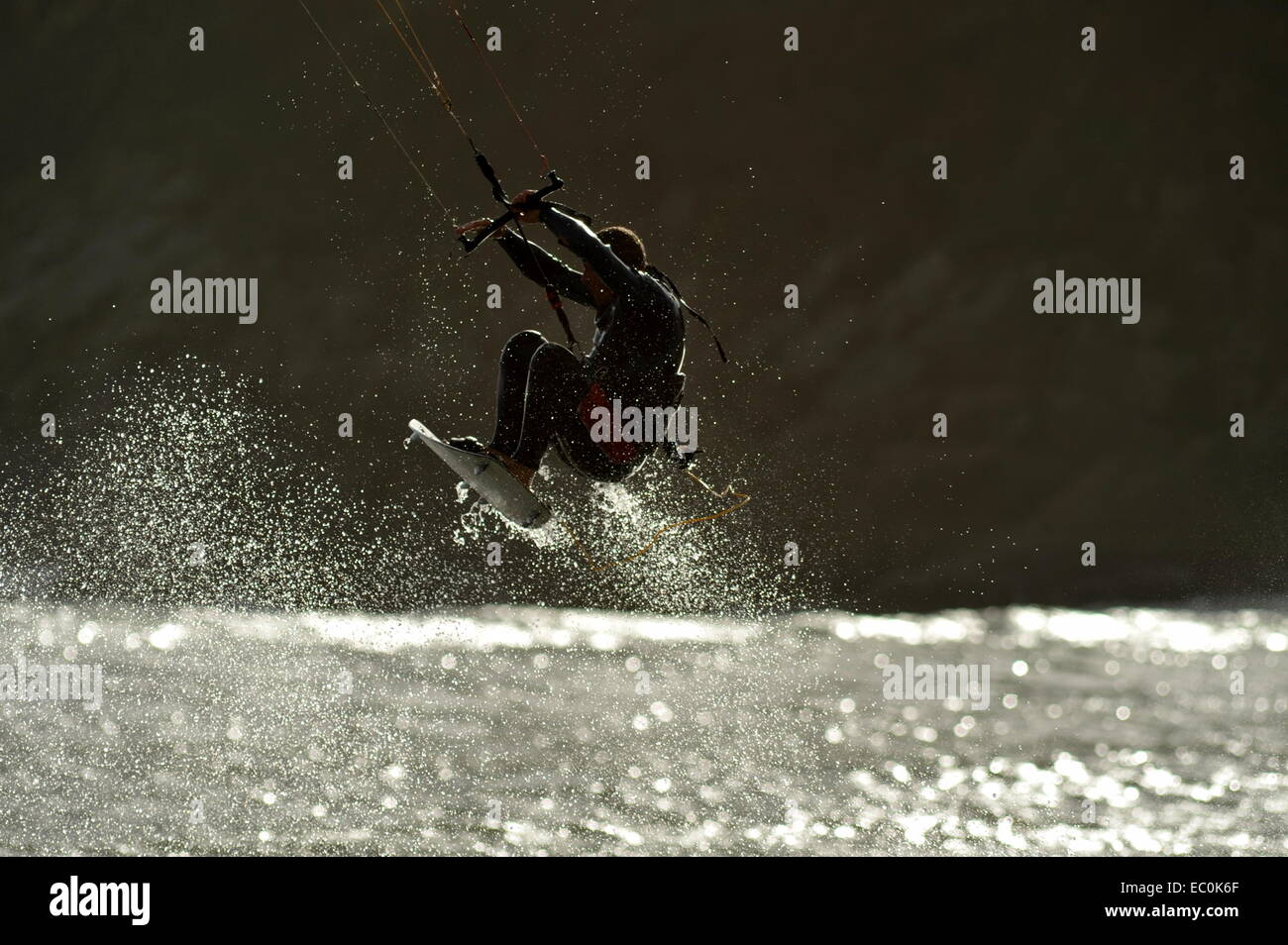Kite surf en spray silueteado como él vuela alto por encima de la onda Foto de stock