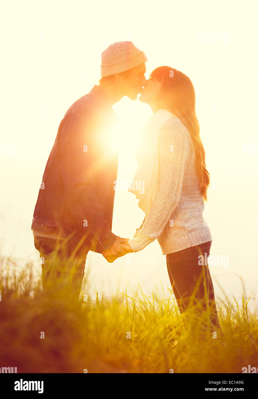 Pareja joven en el amor, los besos al atardecer Foto de stock