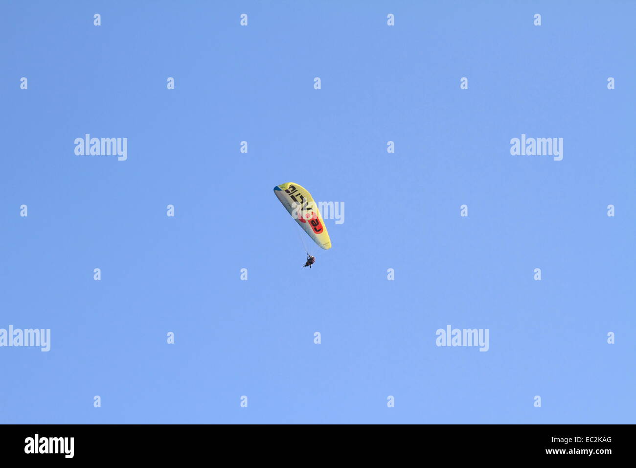 Impresionante deporte de aventura. Persona en el cielo azul haciendo deporte deslizamiento de Pará. Gravedad TANDEM Parapente, Pará Fetiye, Turquía Foto de stock