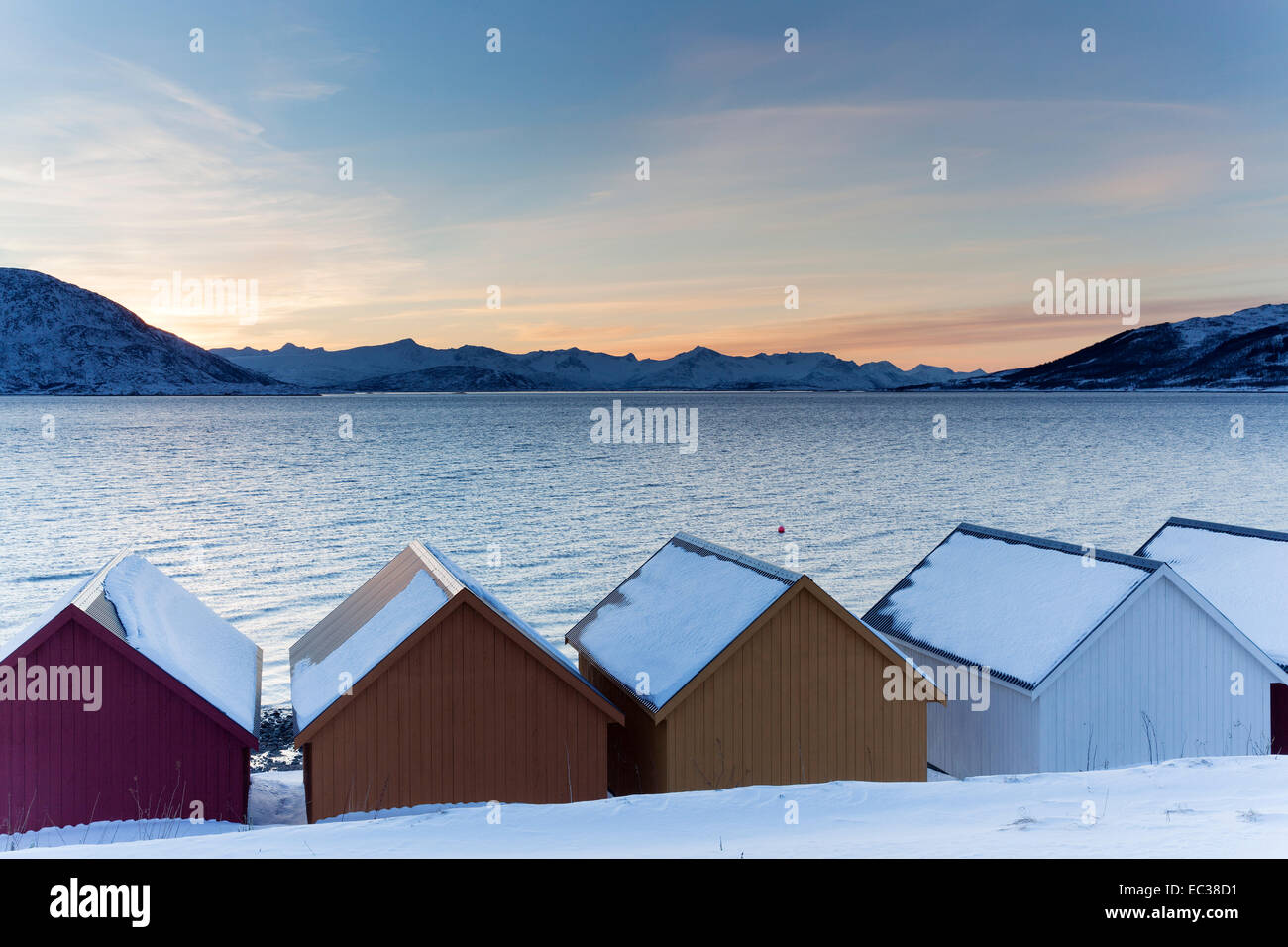 Cabañas de madera de color en el Nordfjord, Kvaløya, Troms, Noruega Foto de stock