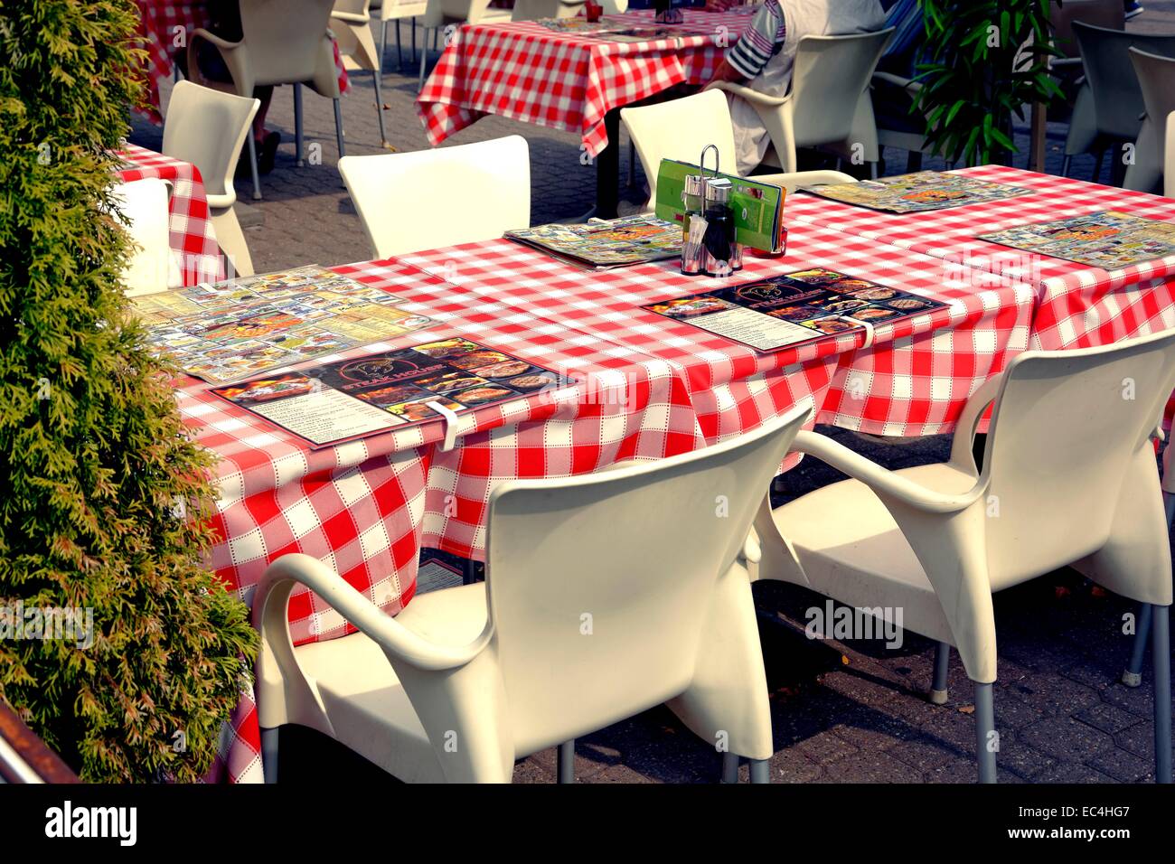 Mesa de invitados con manteles a cuadros rojo-blanco y menú Foto de stock