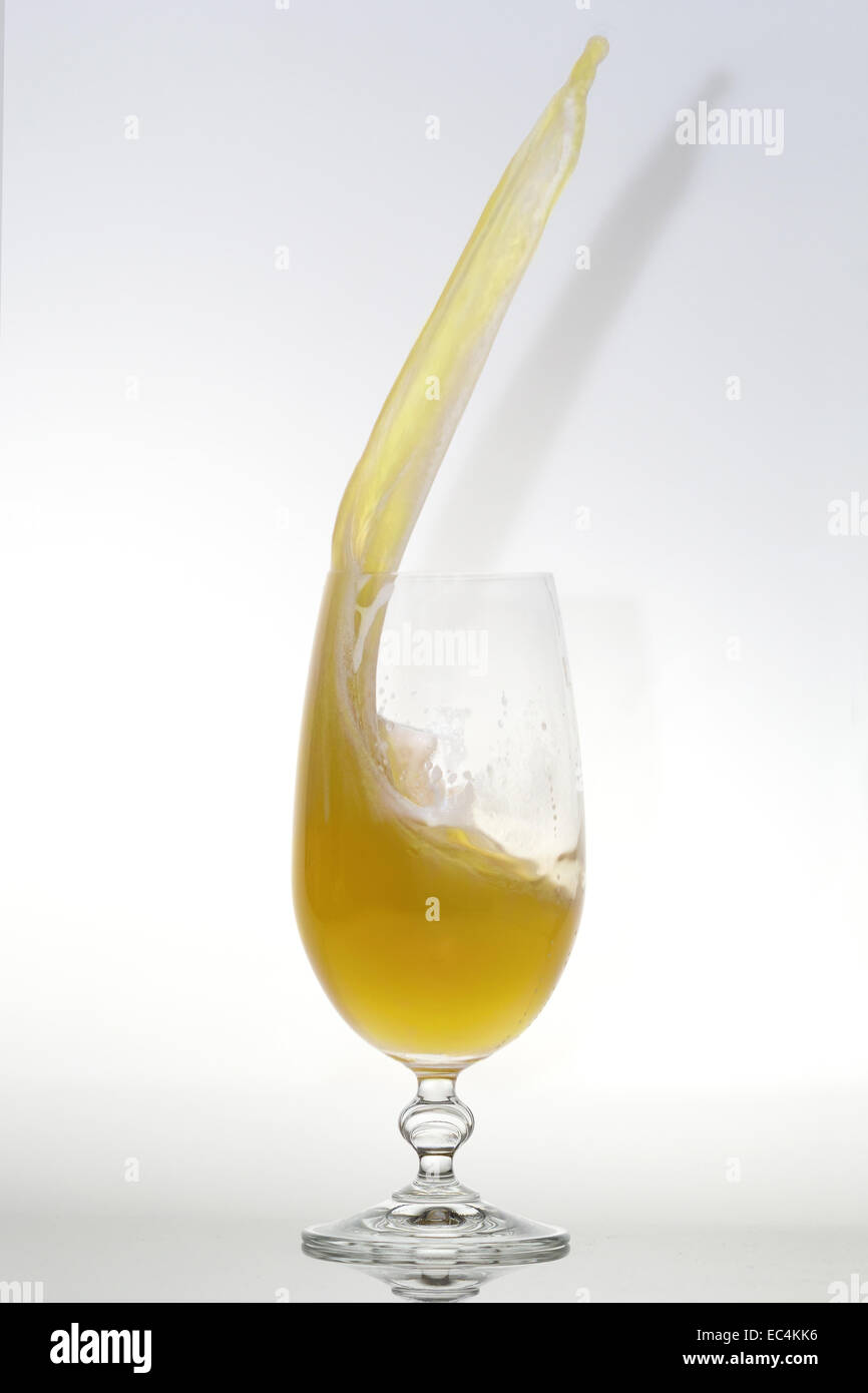 Las salpicaduras de cerveza en un vaso con poca espuma Foto de stock