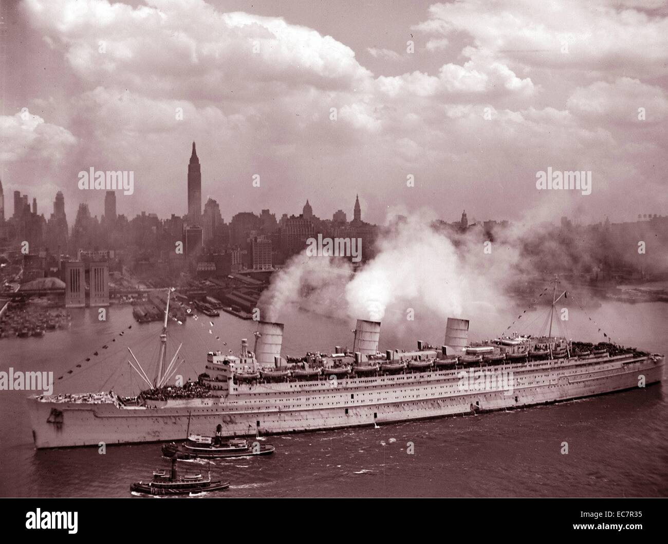 Fotografía del RMS Queen Mary llegando en el puerto de Nueva York con miles de soldados estadounidenses. Fecha 1945 Foto de stock