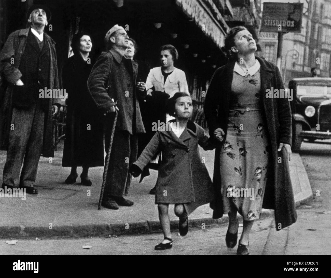 Un niño y su madre corriendo de la vivienda desde los ataques aéreos  durante la Guerra Civil Española. Esta imagen fue tomada en Bilbao, España,  fechada alrededor de 1937 Fotografía de stock -