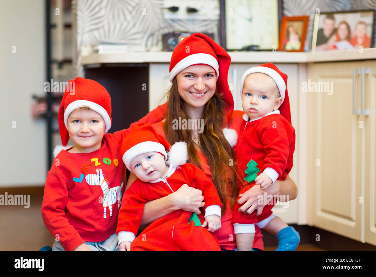 Madre con hijos, baby Santas ayudantes. Feliz Navidad y Año Nuevo concepto Foto de stock