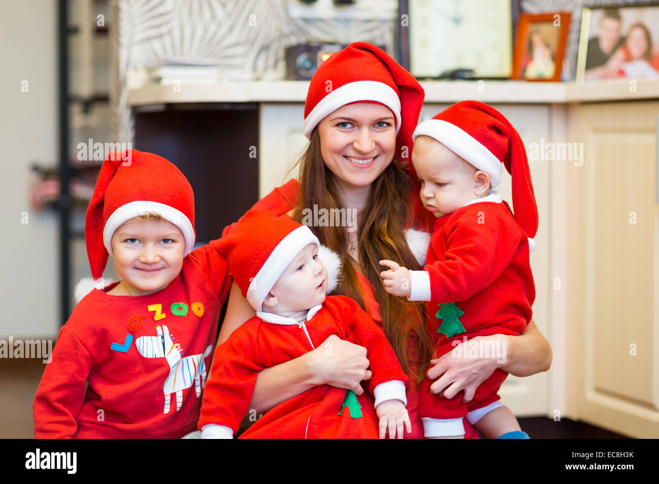 Madre con hijos, baby Santas ayudantes. Feliz Navidad y Año Nuevo concepto Foto de stock