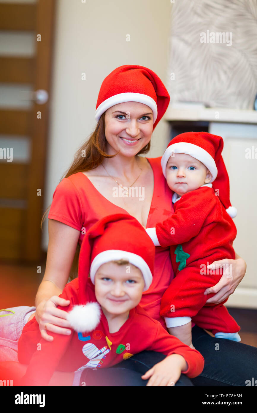 Madre con hijos, baby Santas ayudantes. Feliz Navidad y Año Nuevo concepto Foto de stock