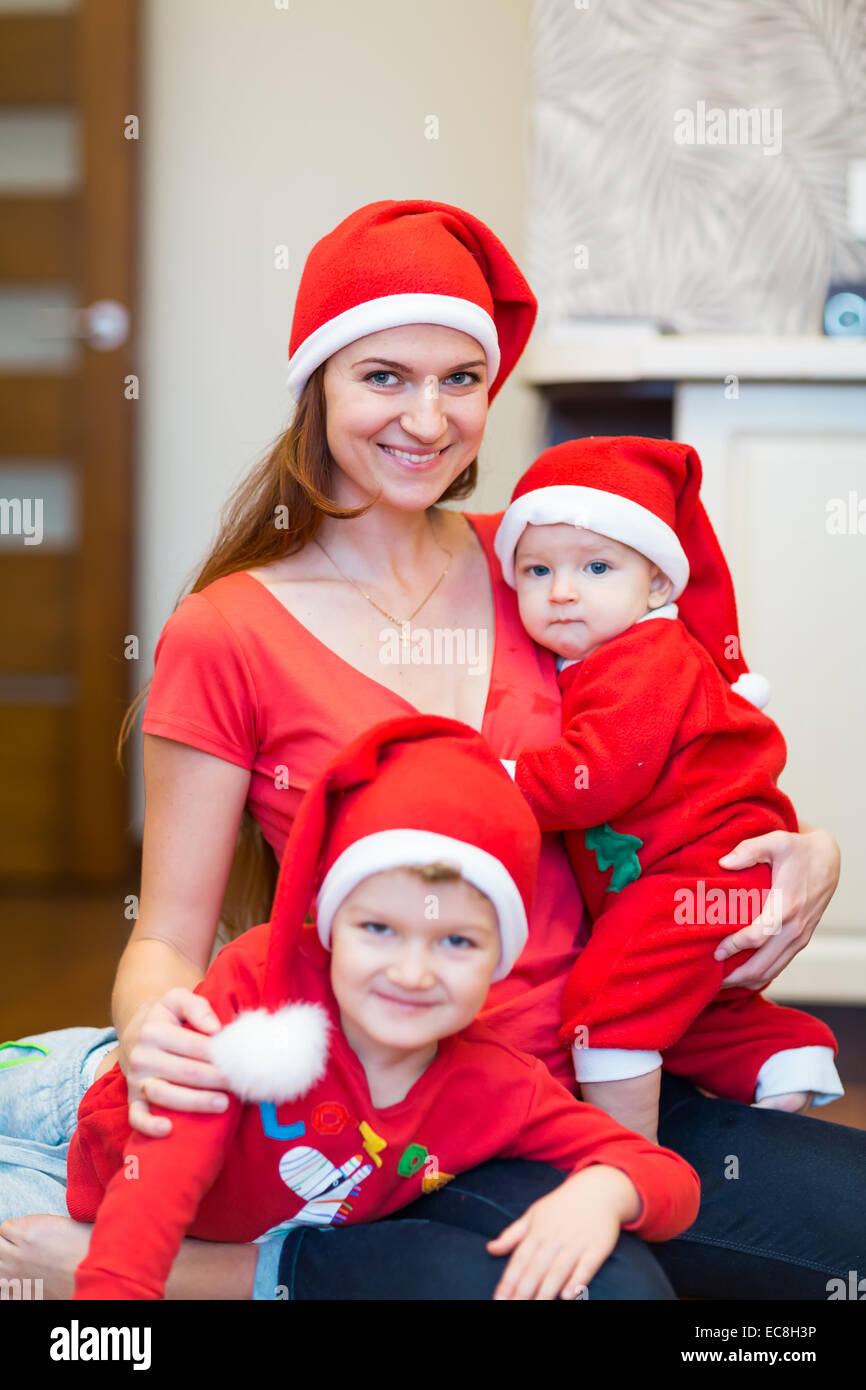 Madre con hijos, baby Santas ayudantes. Feliz Navidad y Año Nuevo concepto Foto de stock