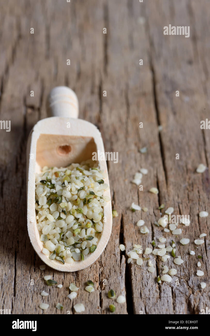 Las semillas de cáñamo en una cuchara de madera rústica contra grunge tabla de madera Foto de stock