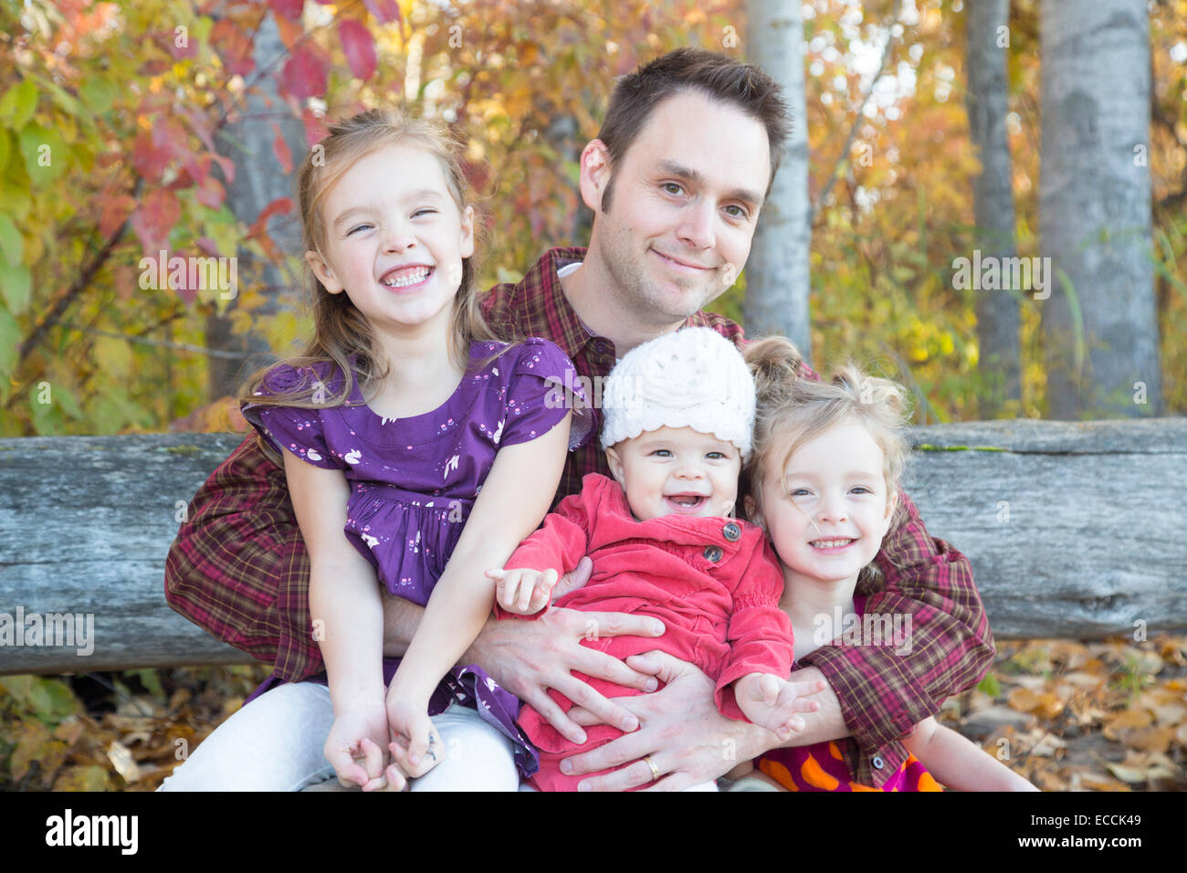 Un padre y sus tres hijas durante una sesión de retrato fotográfico familiares de otoño en Kalispell, Montana. Foto de stock