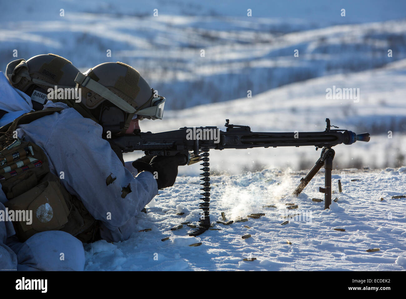 Un soldado del ejército noruego vestidas de blanco camuflaje dispara con una ametralladora a un destino lejano Marzo 6, 2013 durante los ejercicios de fuego vivo al norte del Círculo Polar Ártico en Skjold, Noruega. Foto de stock