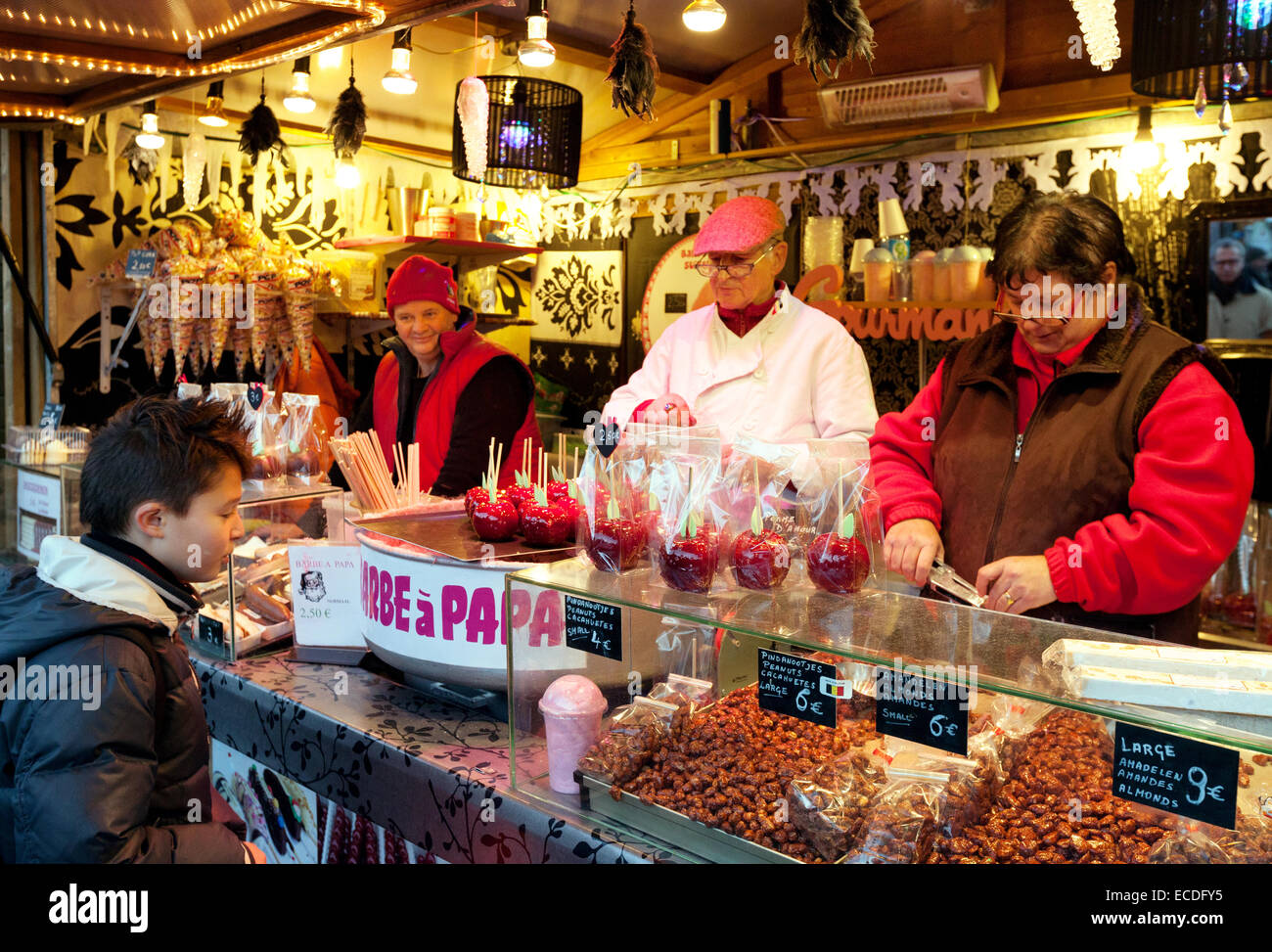 Un joven niño comprando un toffee manzana en un establo, brujas, Mercado de Navidad de la plaza Markt, en Brujas, Bélgica, Europa Foto de stock