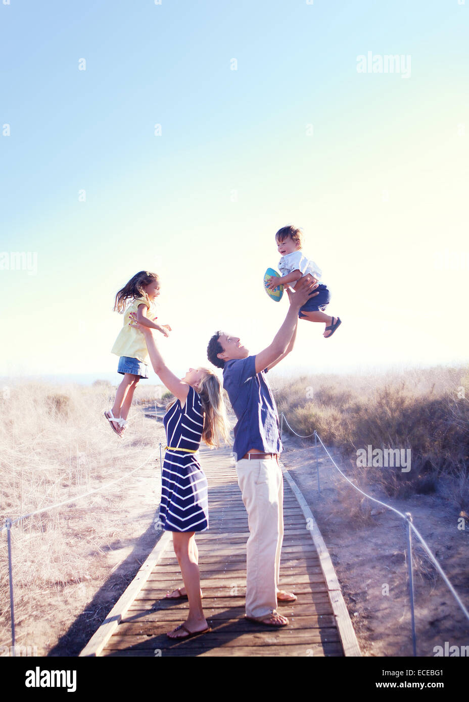 Dos padres que mantienen a sus hijos en el aire, California, EE.UU Foto de stock