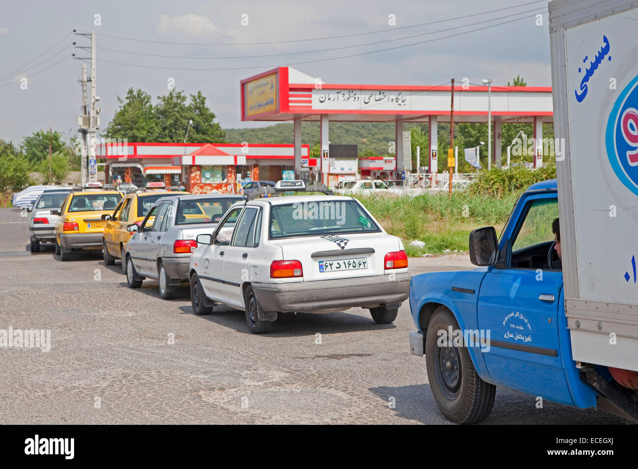 Coches en cola en frente de la estación de gasolina / estación de servicio en Irán Foto de stock