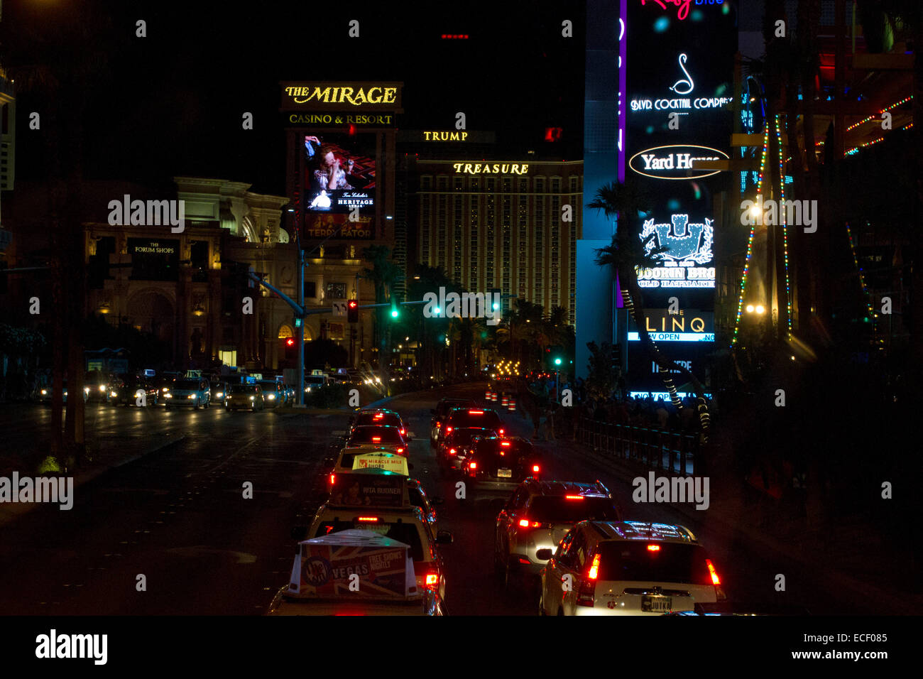 Escena nocturna del tráfico a lo largo de la Strip de Las Vegas y diversos hoteles y casinos: Mirage, Treasure Island, Trump & Street Signs Foto de stock