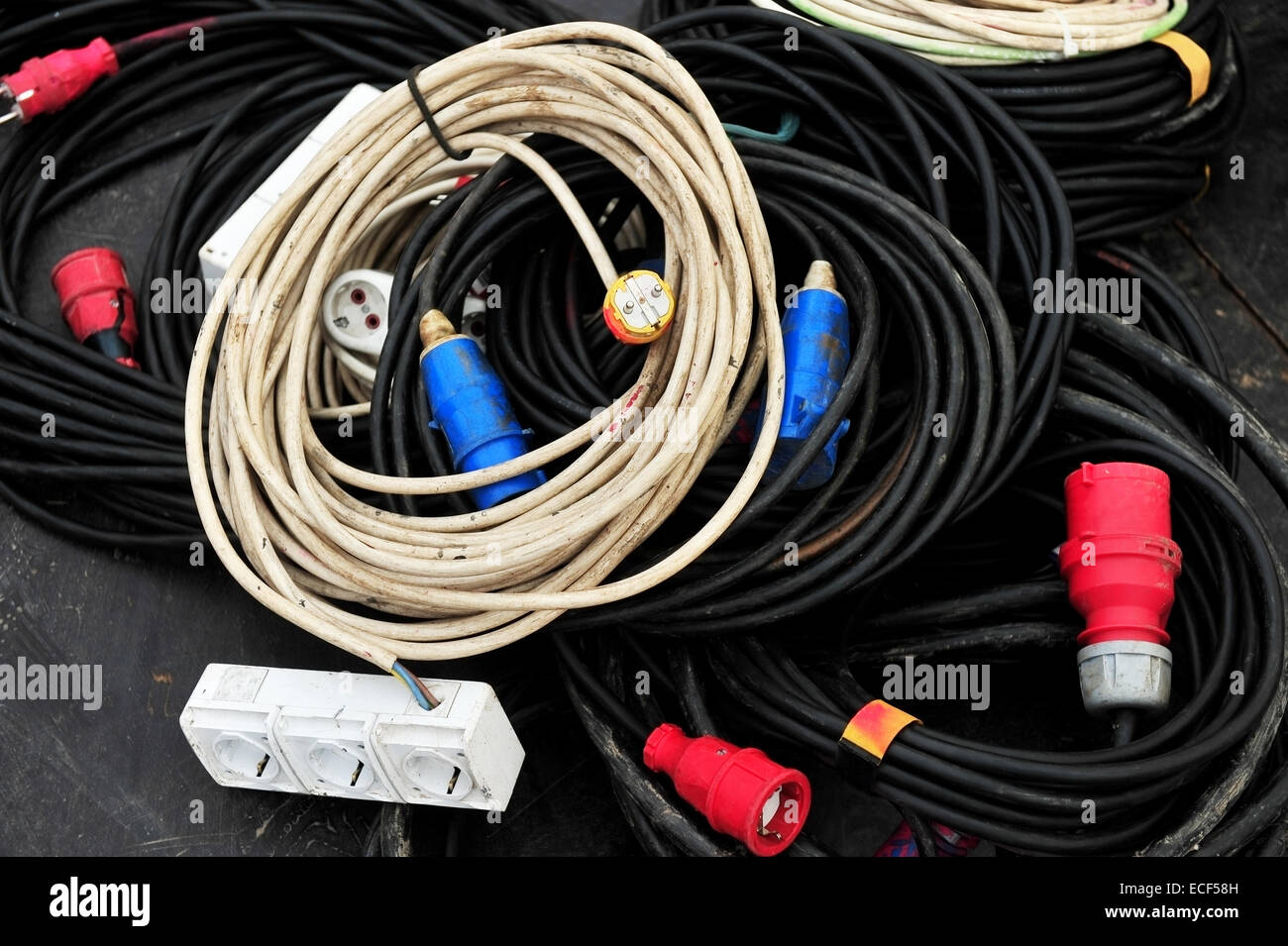 Varios cables de energía eléctrica con alargadores y enchufes Foto de stock