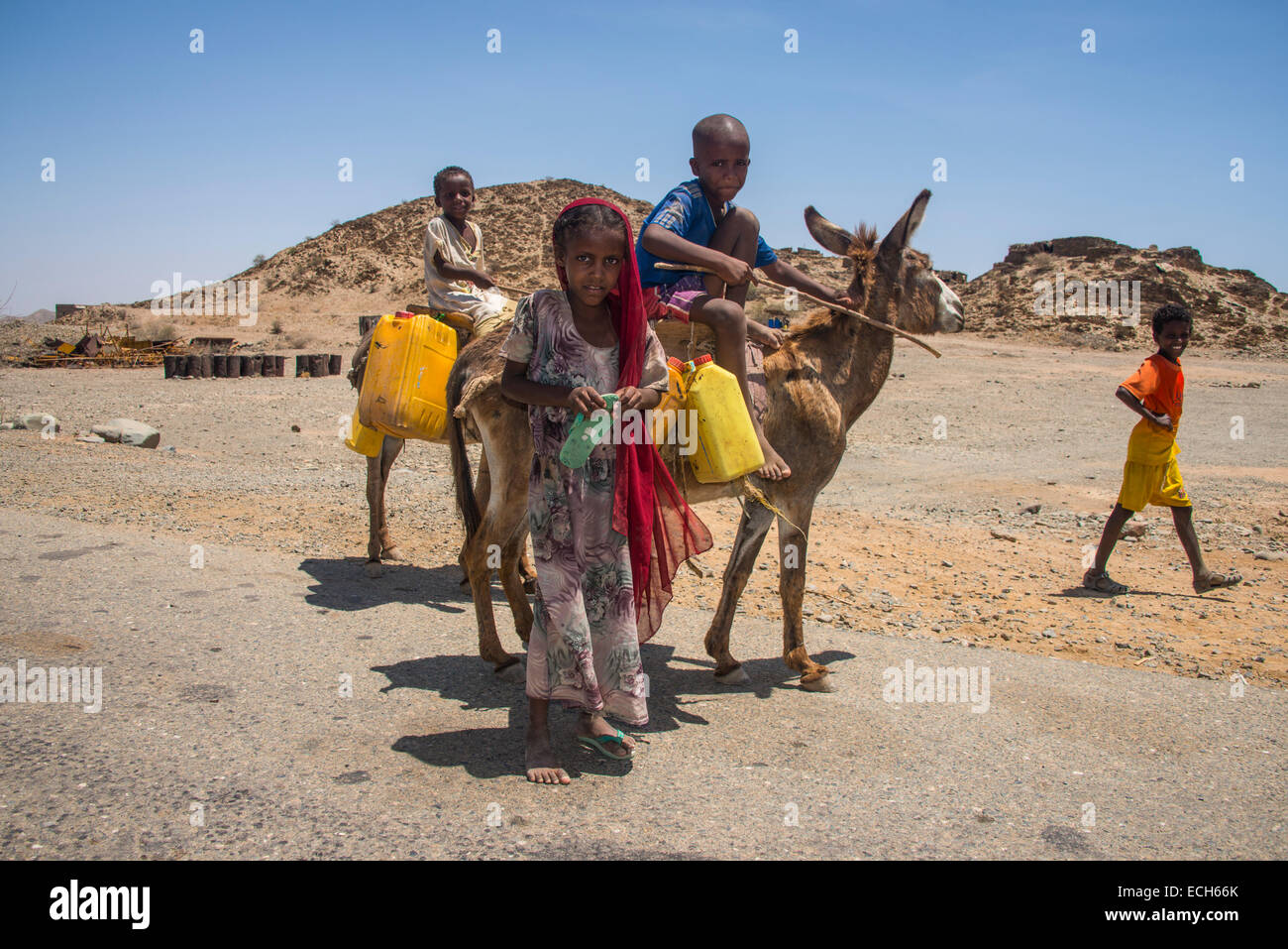 Los niños con un burro en el camino a un abrevadero, en las tierras bajas, Eritrea Foto de stock
