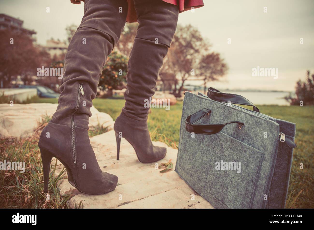 Foto vintage de las piernas de la mujer con botas altas y mano bolsa cerca  de la hierba Fotografía de stock - Alamy