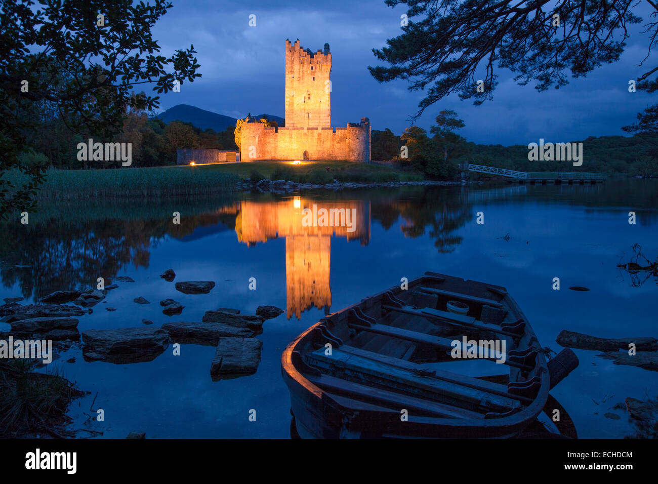 Barco de pesca y el castillo Ross iluminada al anochecer, Lough Leane, Parque Nacional de Killarney, condado de Kerry, Irlanda. Foto de stock
